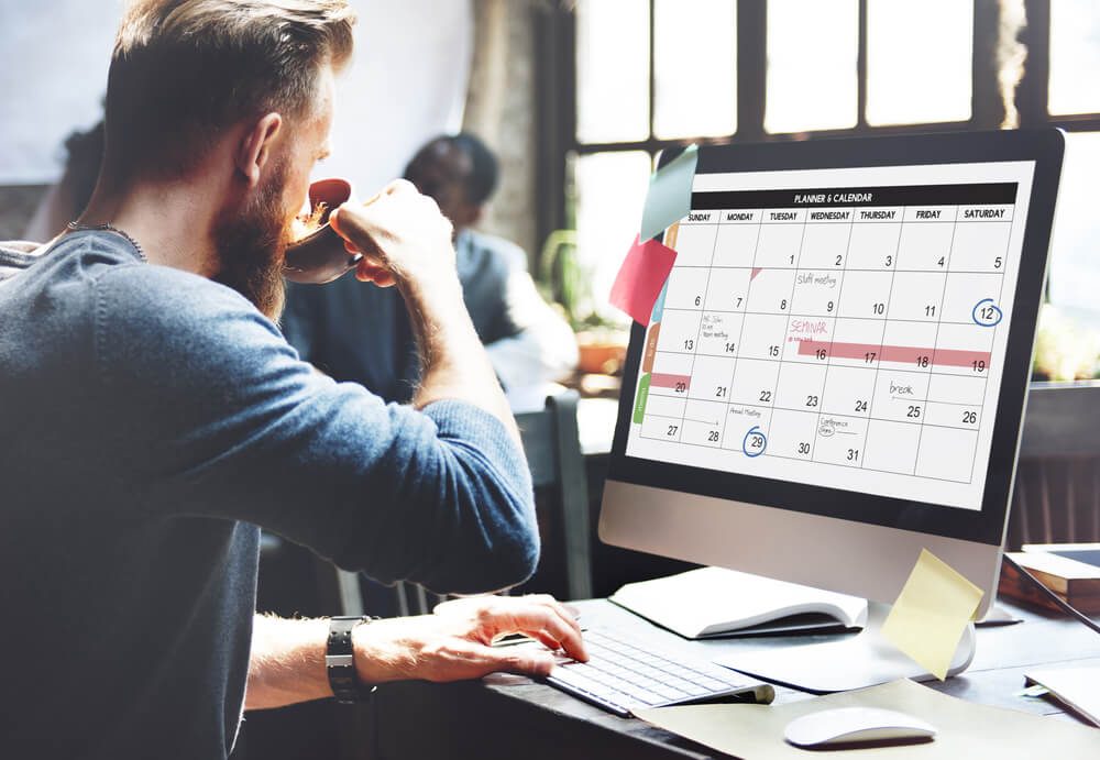 man looking at callendar on computer